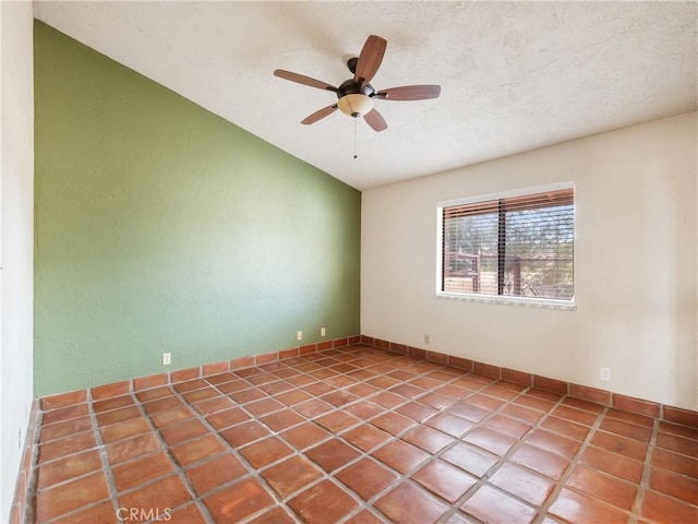 empty room featuring a textured ceiling, lofted ceiling, and ceiling fan