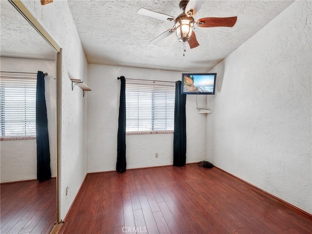 unfurnished room featuring hardwood / wood-style floors and a textured wall