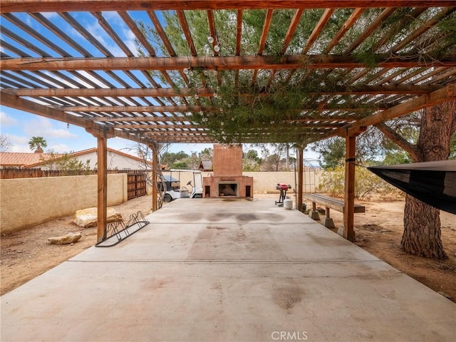 view of patio / terrace featuring exterior fireplace, a pergola, and fence