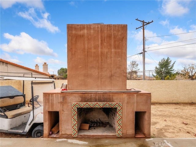 view of patio featuring fence and a tile fireplace