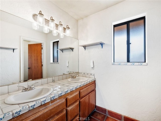 bathroom featuring double vanity, baseboards, tile patterned floors, and a sink