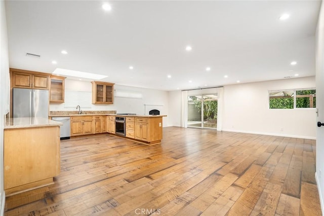 6432 Weber Cir, Huntington Beach, CA 92647 - kitchen featuring light wood-style flooring, a sink, open floor plan, a peninsula, and stainless steel appliances