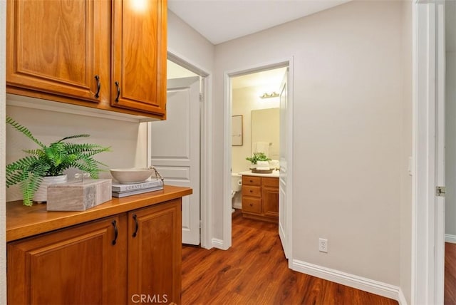 hall featuring baseboards and dark wood-type flooring