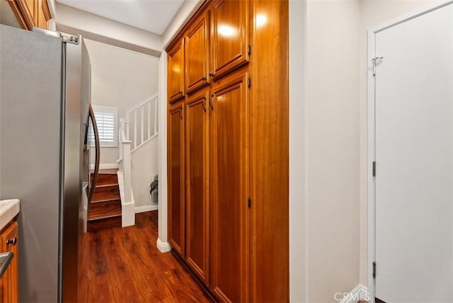 hall with baseboards, dark wood-type flooring, and stairs