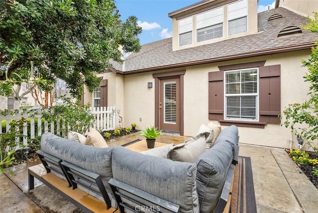 rear view of property featuring stucco siding, an outdoor hangout area, and a patio