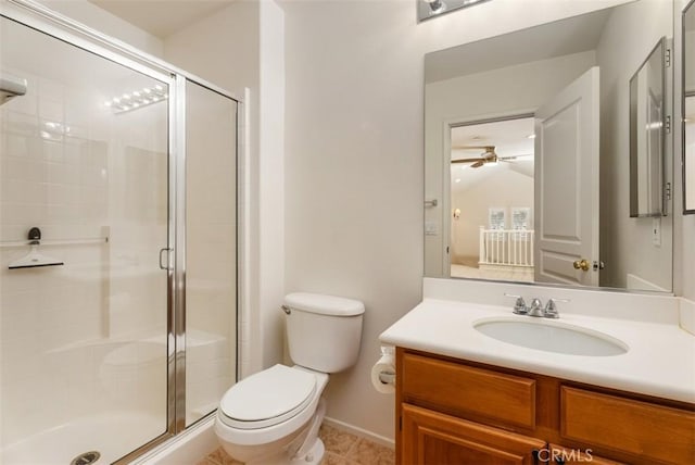 bathroom with a shower stall, toilet, vanity, and a ceiling fan