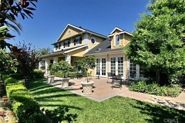 back of house with a patio area, a yard, and french doors