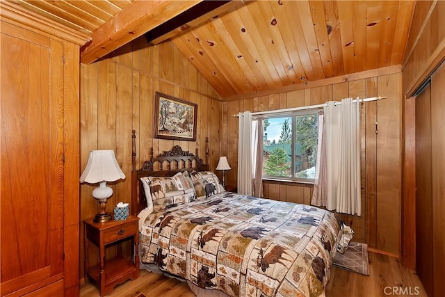 bedroom with lofted ceiling with beams, wooden walls, wood ceiling, and wood finished floors