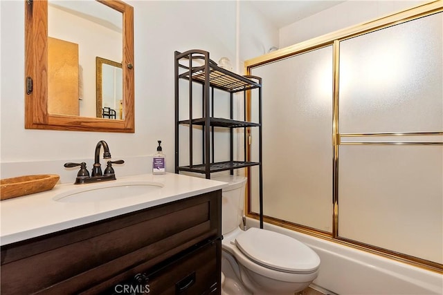 full bathroom featuring vanity, toilet, and bath / shower combo with glass door