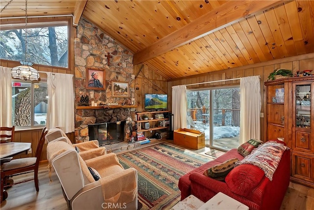 living room featuring beam ceiling, wood finished floors, and wooden ceiling