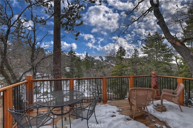 snow covered deck featuring outdoor dining space