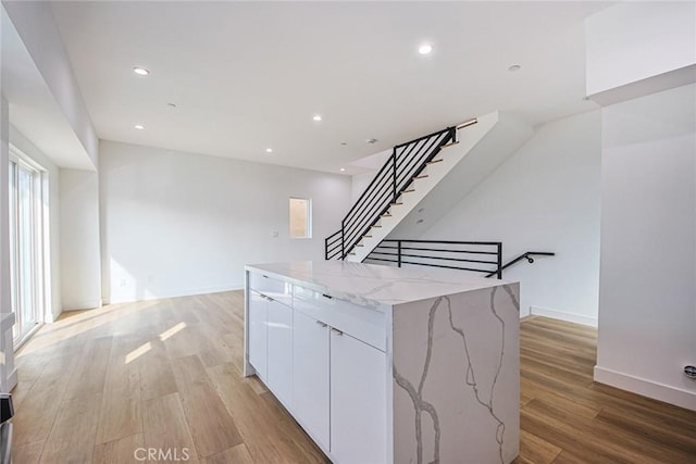 kitchen featuring modern cabinets, light wood-style flooring, a center island, recessed lighting, and white cabinets