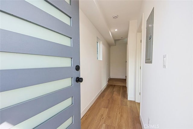 hall with recessed lighting, baseboards, electric panel, and light wood finished floors