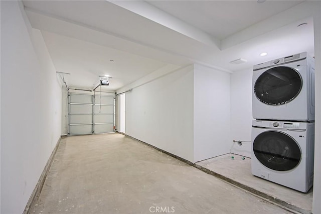 laundry room featuring laundry area, stacked washer / dryer, and a garage