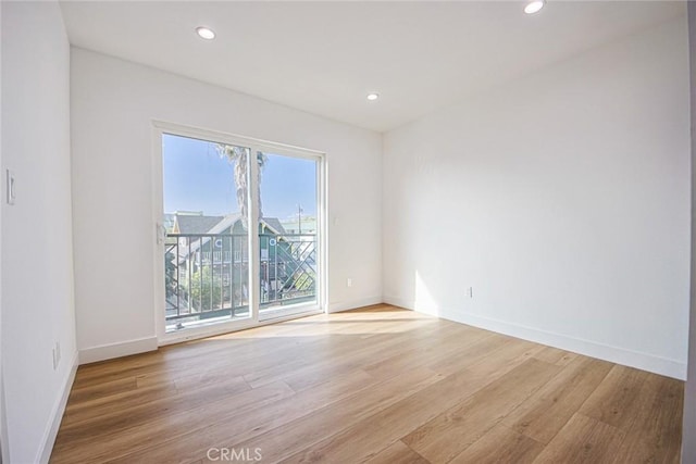 unfurnished room with recessed lighting, light wood-type flooring, and baseboards