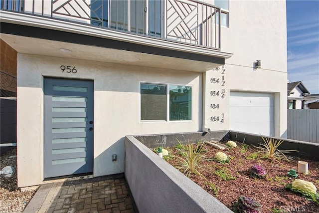 doorway to property featuring a balcony and stucco siding