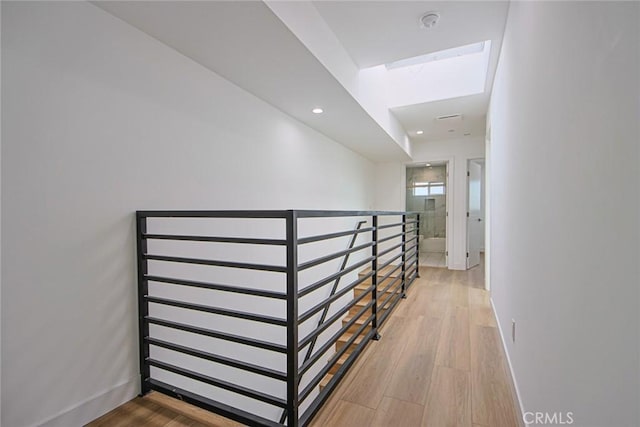 corridor featuring an upstairs landing, recessed lighting, light wood-style flooring, and baseboards