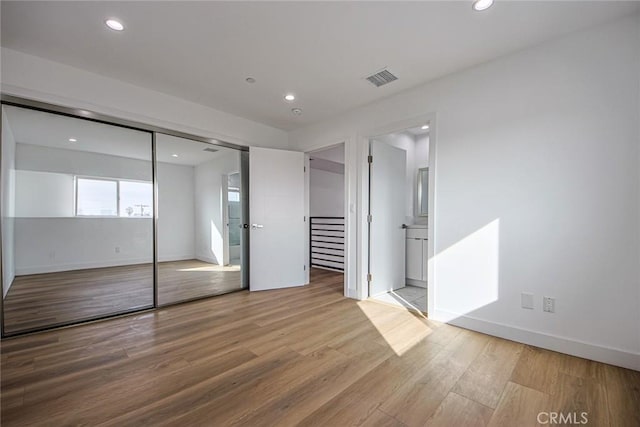 unfurnished bedroom with light wood finished floors, visible vents, recessed lighting, and baseboards