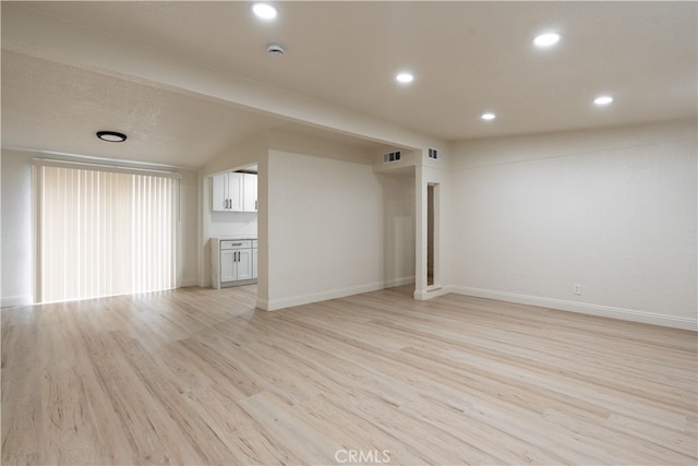 unfurnished living room with light wood finished floors, visible vents, recessed lighting, and baseboards