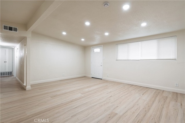 below grade area with recessed lighting, visible vents, baseboards, and wood finished floors