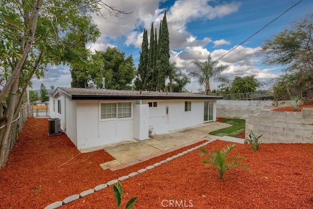 rear view of property featuring a patio area, cooling unit, a fenced backyard, and stucco siding