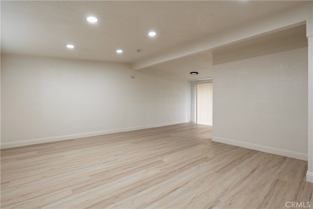 unfurnished room with lofted ceiling with beams, light wood-style flooring, recessed lighting, and baseboards