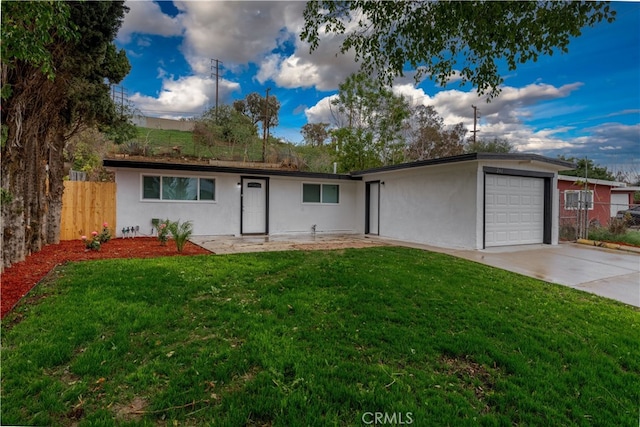 single story home featuring a garage, a front yard, stucco siding, and fence