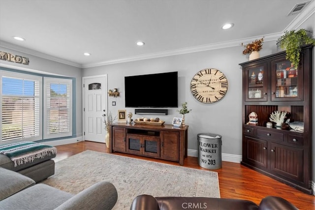 living area featuring recessed lighting, crown molding, baseboards, and wood finished floors