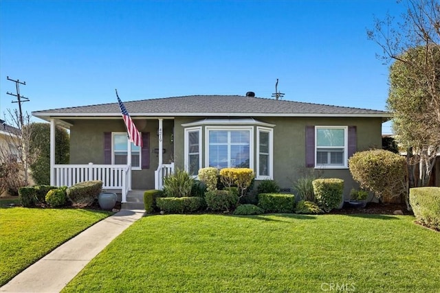 bungalow-style home with stucco siding, a porch, a shingled roof, and a front lawn