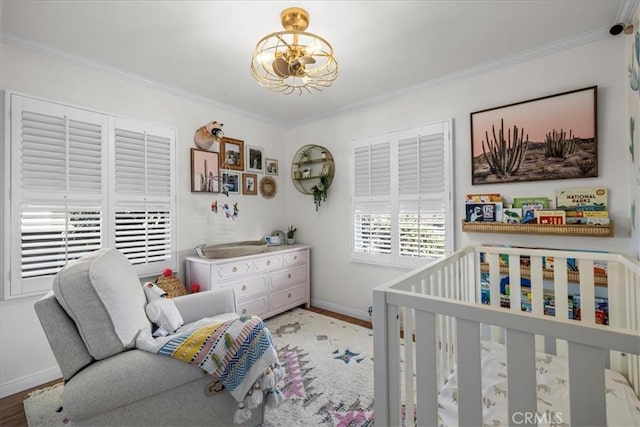 bedroom featuring baseboards, wood finished floors, a notable chandelier, and ornamental molding