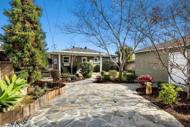 rear view of property featuring stucco siding and a patio area