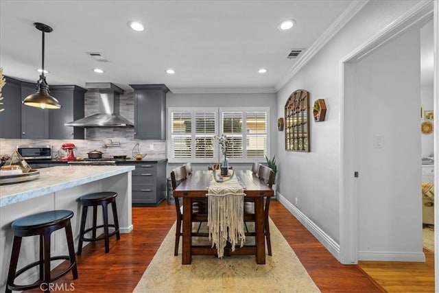 dining space with dark wood finished floors, crown molding, baseboards, and visible vents