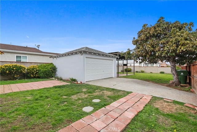 exterior space with a garage, an outbuilding, concrete driveway, and fence