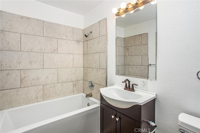 bathroom featuring toilet, vanity, and washtub / shower combination