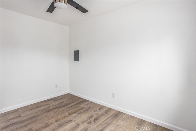 empty room featuring baseboards, wood finished floors, and ceiling fan