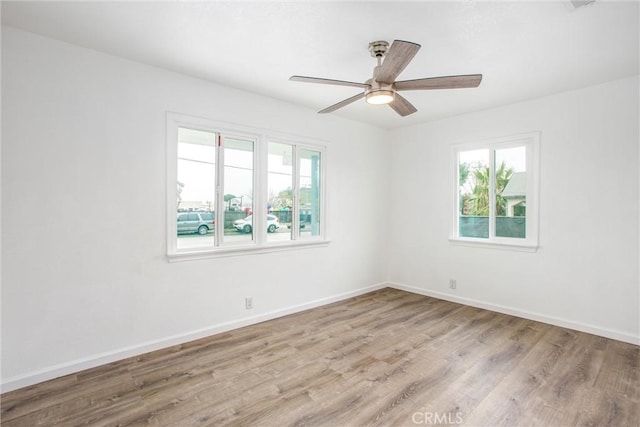 empty room with ceiling fan, baseboards, and wood finished floors