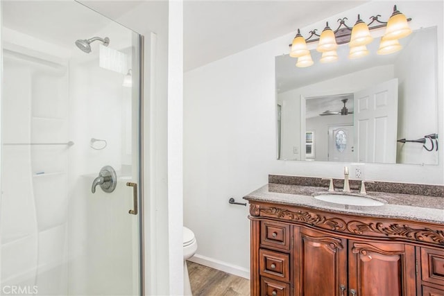 full bathroom featuring vanity, toilet, wood finished floors, and a shower stall