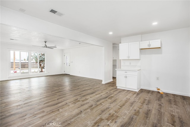 unfurnished living room with recessed lighting, wood finished floors, visible vents, and baseboards