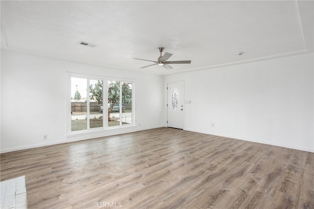 unfurnished room featuring visible vents, baseboards, ceiling fan, and wood finished floors