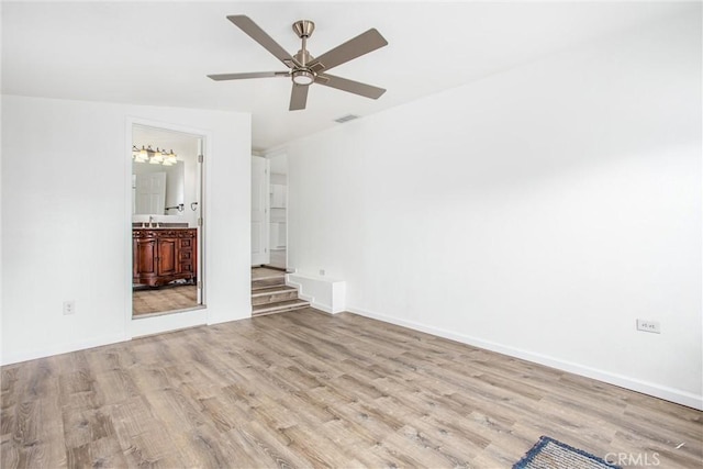 unfurnished bedroom with visible vents, connected bathroom, ceiling fan, baseboards, and wood finished floors