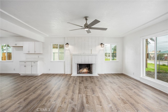 unfurnished living room with a healthy amount of sunlight, light wood-style floors, and ceiling fan