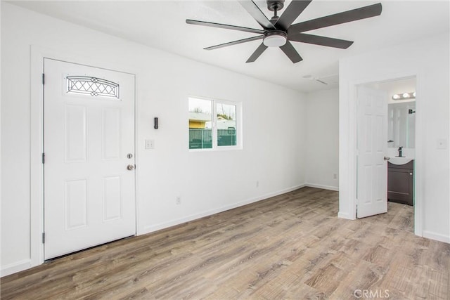 foyer featuring baseboards, light wood-type flooring, and a ceiling fan