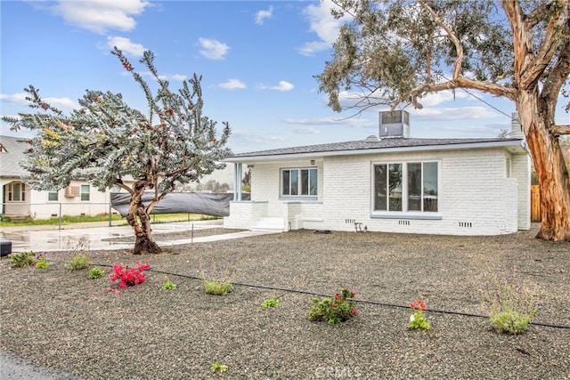 view of front of property with brick siding, fence, central AC unit, crawl space, and a patio