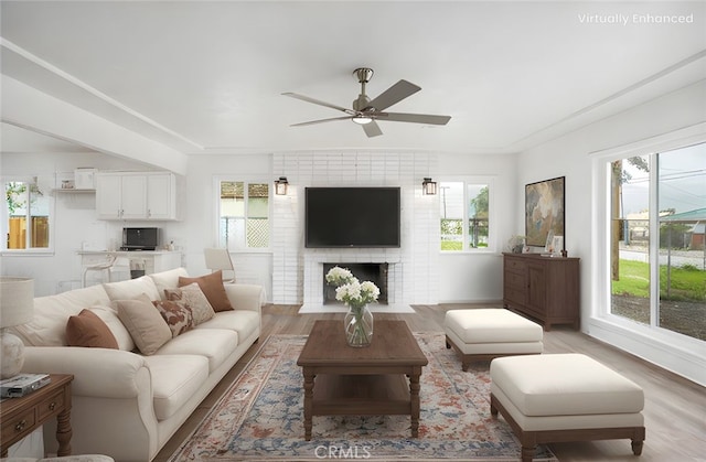 living area with light wood-type flooring, plenty of natural light, and ceiling fan