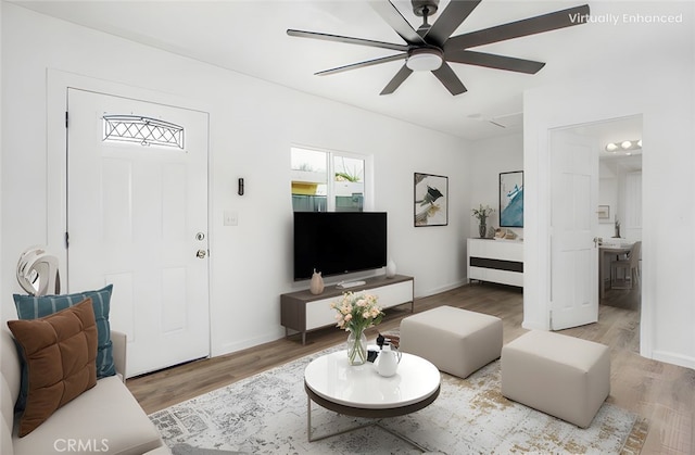 living room with wood finished floors, baseboards, and ceiling fan