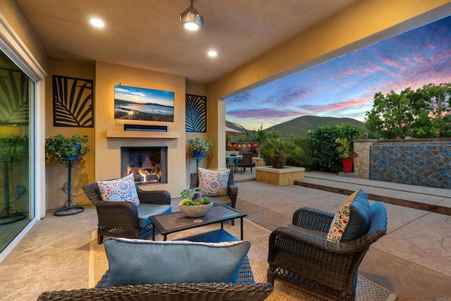 view of patio / terrace with an outdoor living space with a fireplace