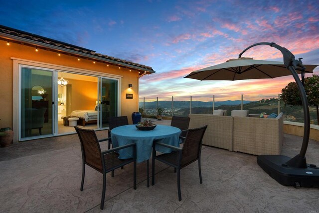 patio terrace at dusk with outdoor dining space and fence