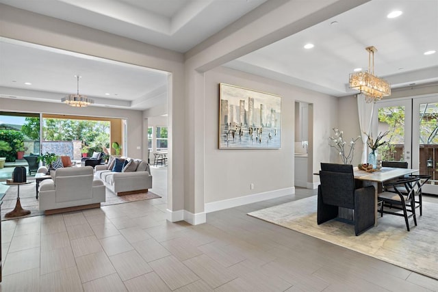 dining space with a chandelier, recessed lighting, baseboards, and a tray ceiling