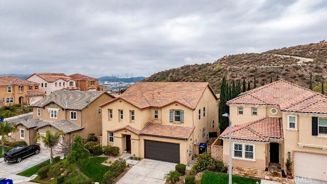 mediterranean / spanish-style home featuring driveway, a garage, a mountain view, and stucco siding