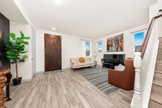 living room with wood finished floors, stairway, healthy amount of natural light, recessed lighting, and baseboards